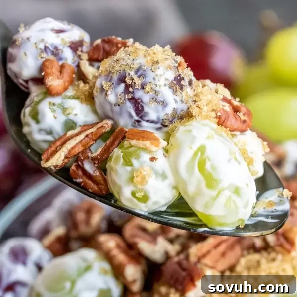 spoonful of Easy Grape Salad with red and green grapes, cream cheese dressing, and pecans