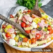 Italian Pasta Salad in a white bowl with wooden serving spoons