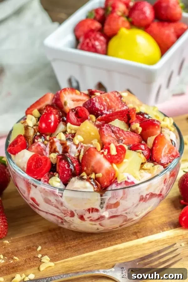 A close-up shot of Banana Split Cheesecake Salad, highlighting the fresh strawberries, juicy pineapples, and sliced bananas within the creamy cheesecake dressing.