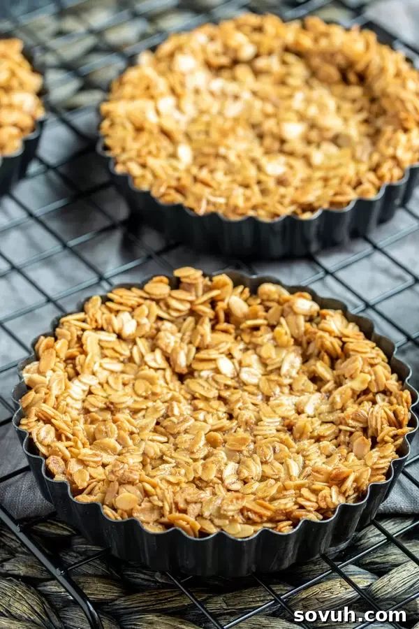 Bowl with granola, softened butter, and honey being mixed to form the tart crust