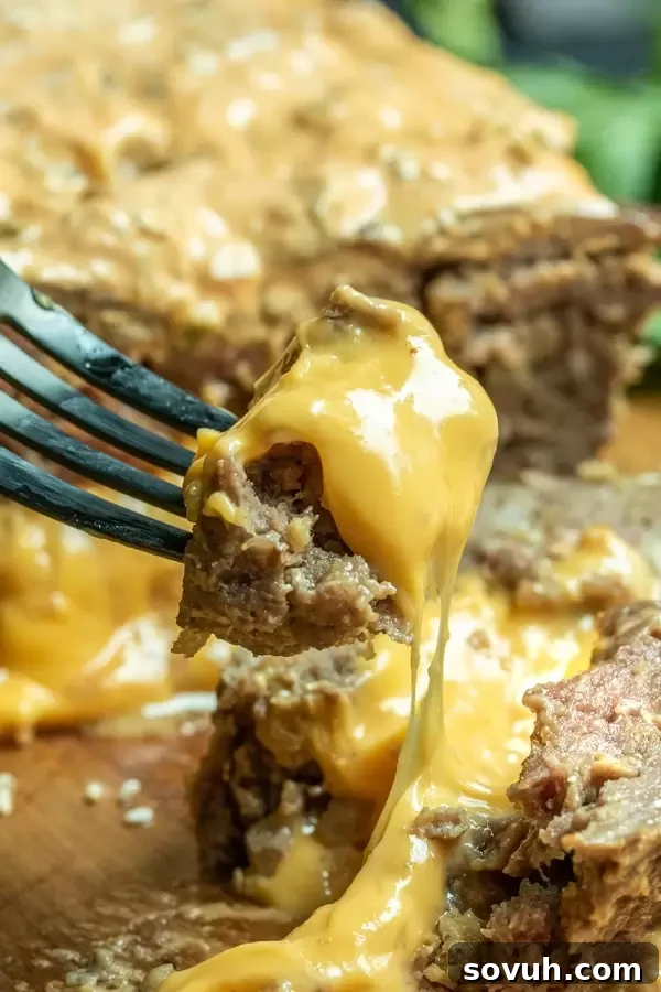 Close-up of a cheesy bite of Big Mac Keto Meatloaf on a fork