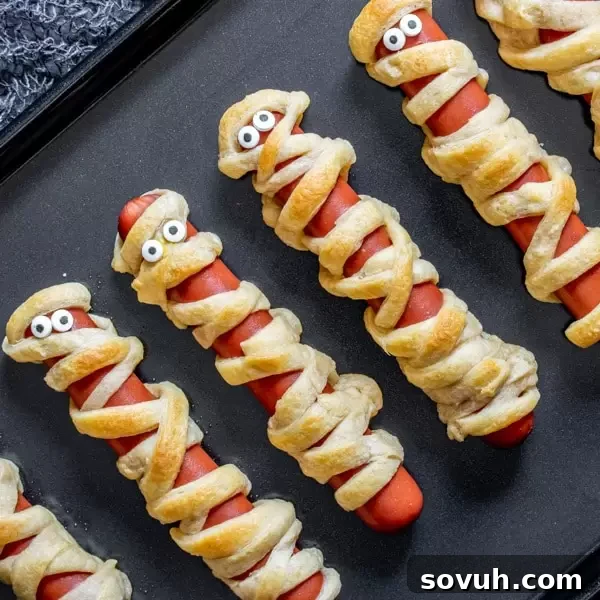 Mummy Dogs, an easy and classic Halloween recipe featuring hotdogs wrapped in crescent rolls.