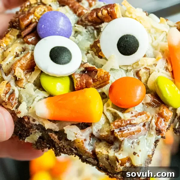 Festive Halloween Magic Cookie Bars, garnished with colorful candy corn.