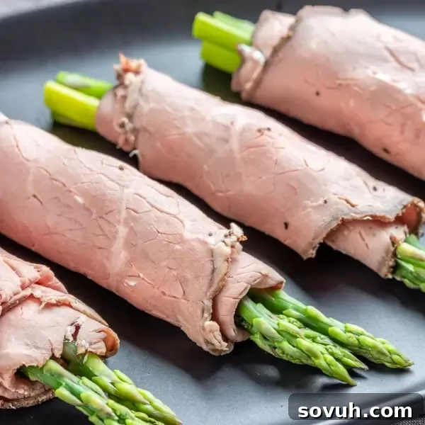 Roast Beef and Asparagus Roll Ups on a black platter