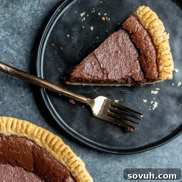 Slice of Chocolate Chess Pie on a white plate with a fork