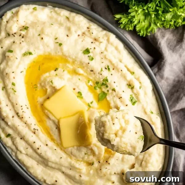 Close-up of creamy low carb cauliflower mash on a spoon, ready to be served during holidays.
