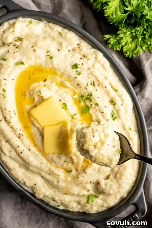 Close-up of low carb cauliflower mash on a spoon, showcasing its creamy texture.