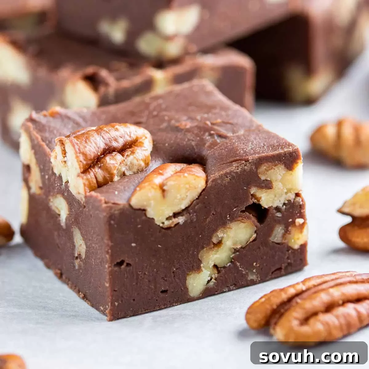 Easy Microwave Fudge with chopped pecans on parchment paper