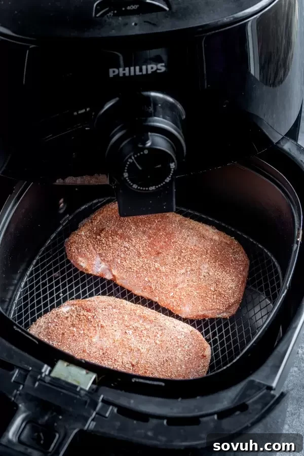 Air Fryer Pork Chops seasoned and ready to cook in a Philips Air Fryer basket.