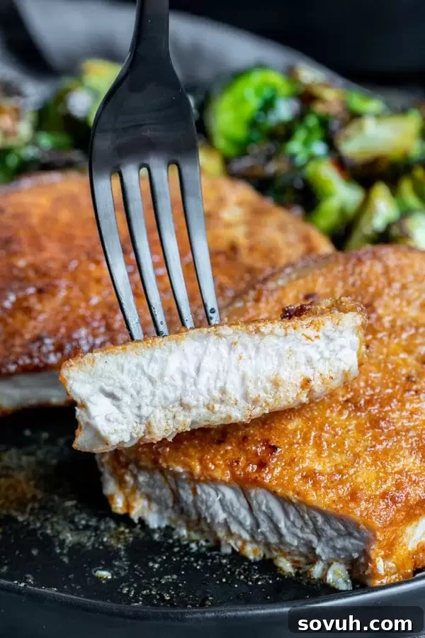 Juicy and moist Air Fryer Pork Chops, showing a cross-section with a perfectly cooked interior.