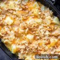 A golden-brown pineapple casserole in a black baking dish, ready for serving.