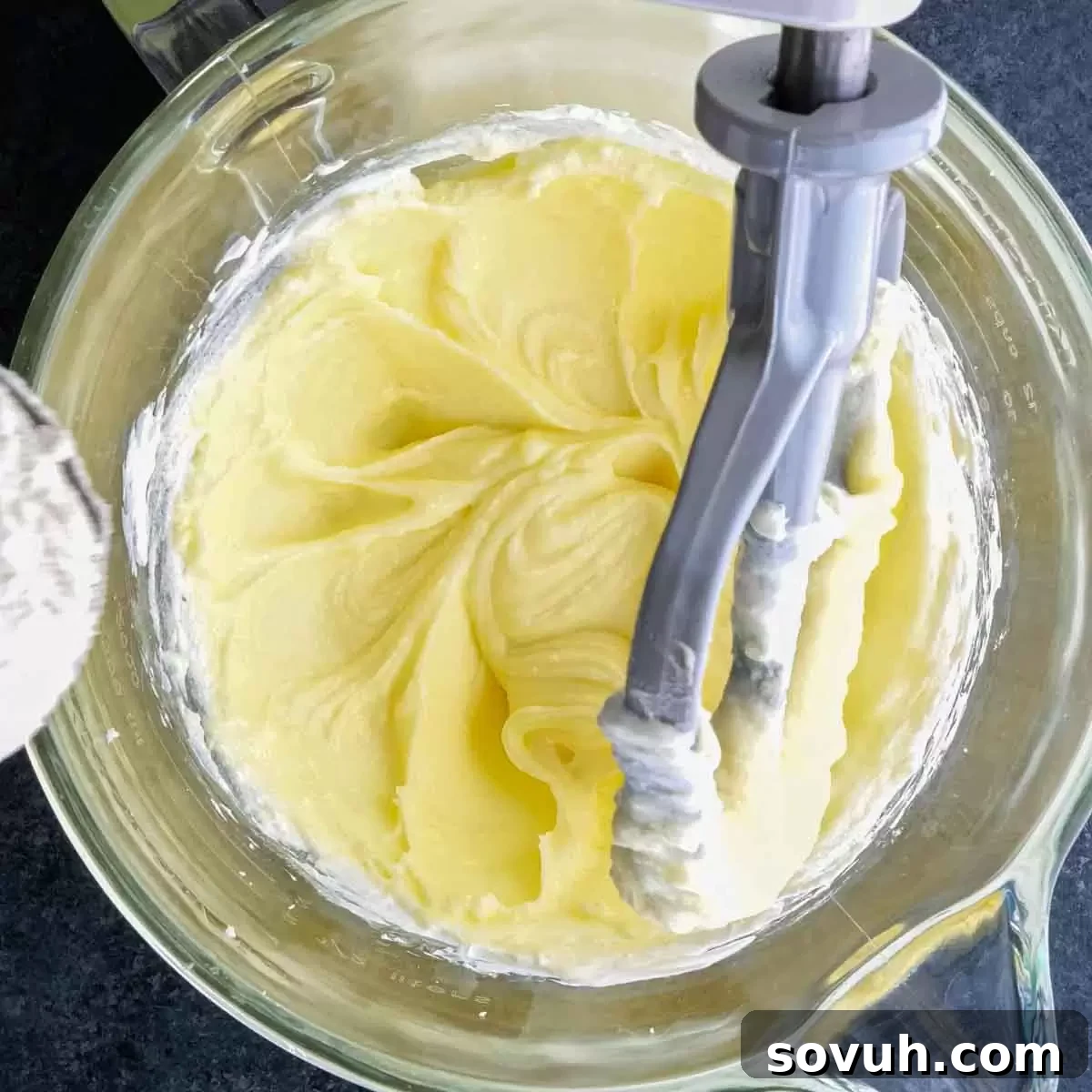A stand mixer blending the cake batter, showing the smooth, creamy consistency of the ingredients.