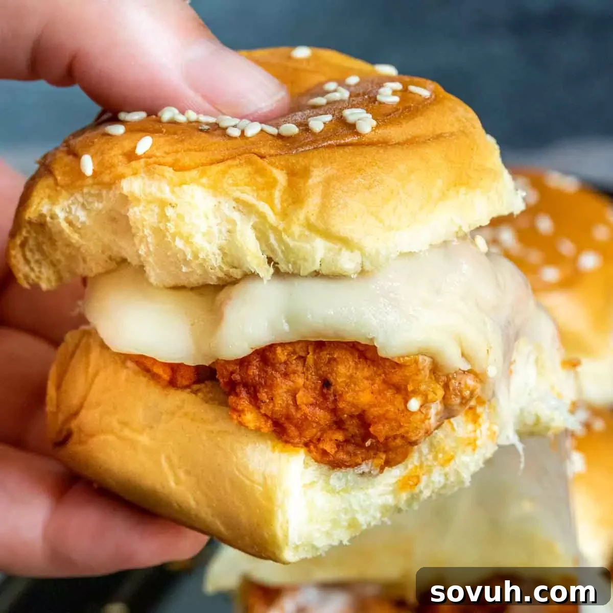 holding buffalo chicken sliders with cheese