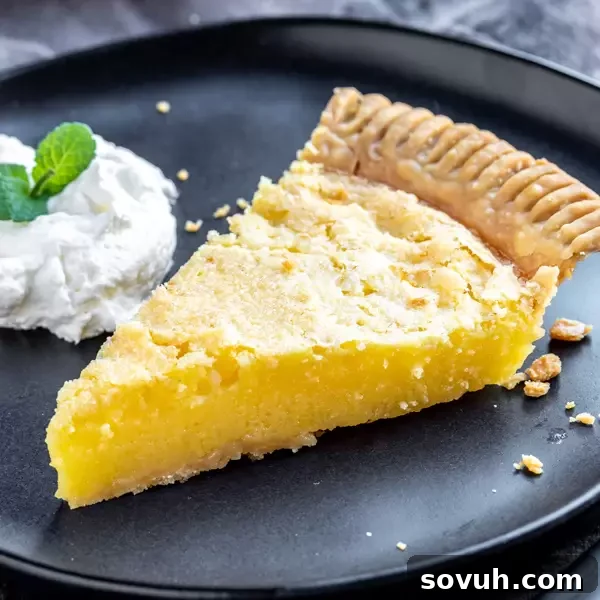 Slice of homemade Lemon Chess Pie on a white plate with a fork