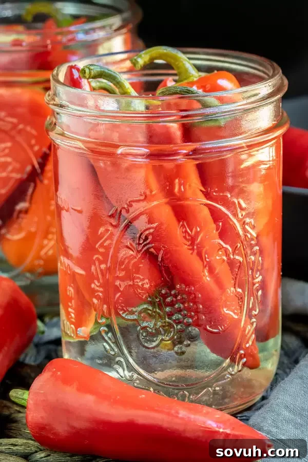 Close-up of southern hot Pepper Sauce with a vibrant red hue in a glass bottle.