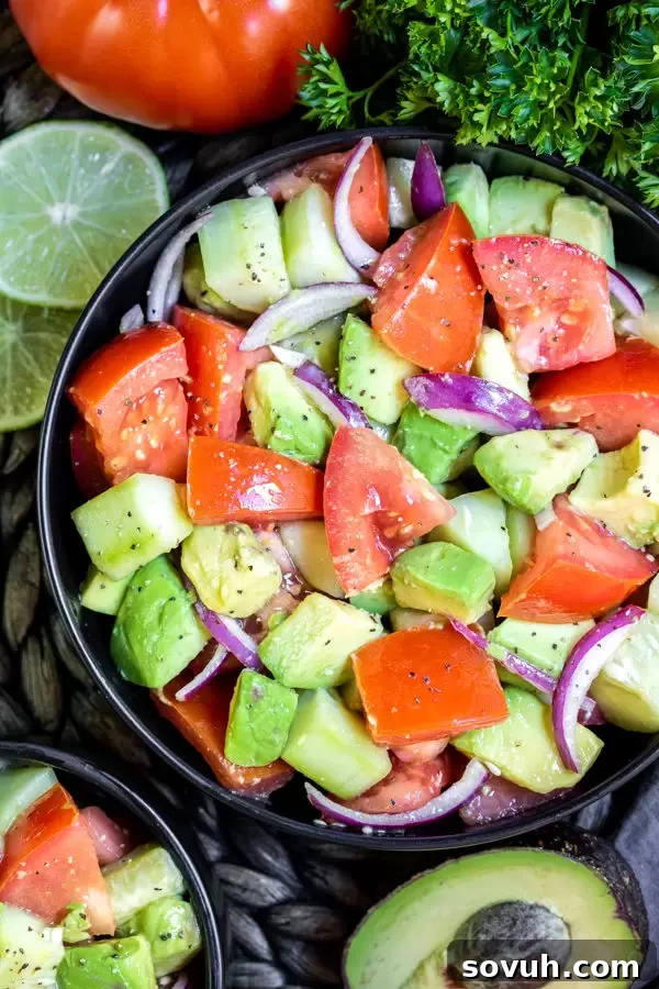 Close-up of a bowl of Cucumber Tomato Avocado Salad, highlighting the colorful fresh vegetables and creamy avocado.