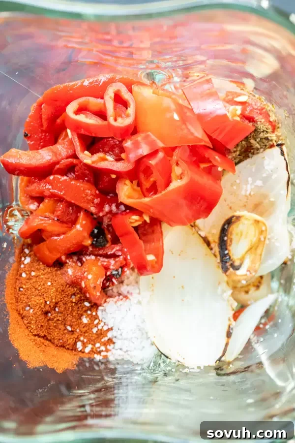 Fresh ingredients for homemade Peri Peri Sauce recipe, including red bell pepper, onions, garlic, and chilies