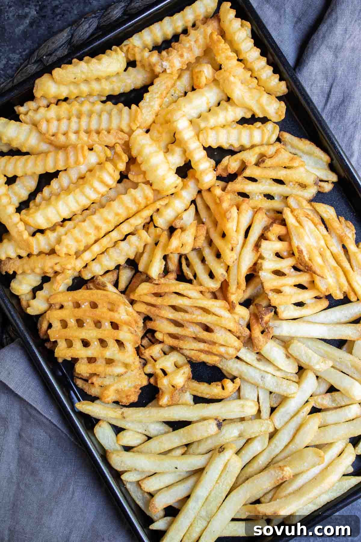 black sheet pan of different types of Air Fryer Frozen French Fries