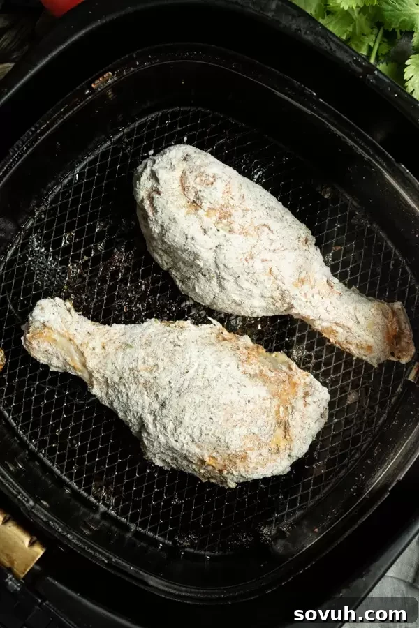 Raw chicken coated in flour and placed in the air fryer