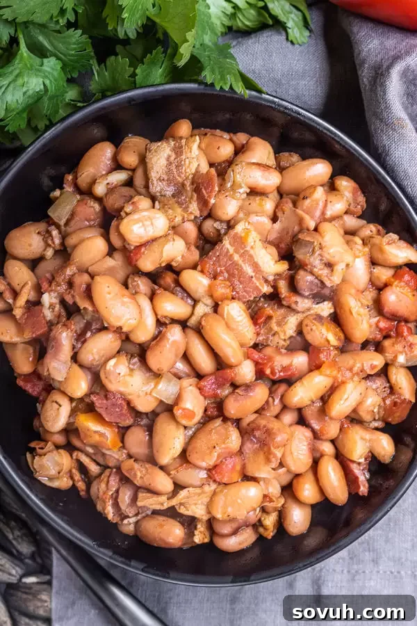 Instant Pot Pinto Beans cooked to perfection with bacon pieces, ready to be scooped and enjoyed.