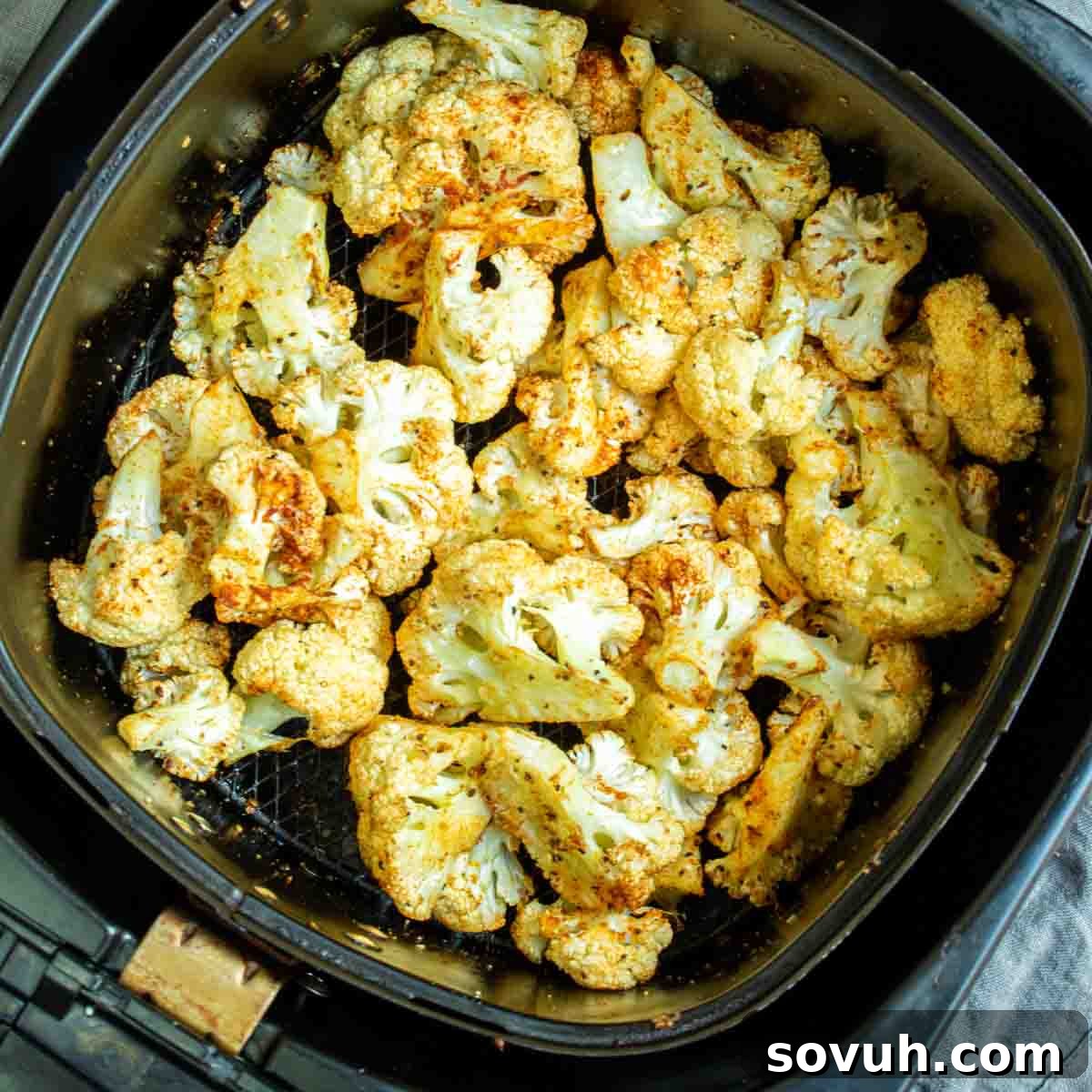 Crispy Air-Fried Cauliflower Bites 2 Golden brown roasted cauliflower florets neatly arranged in an air fryer basket, ready to be served.