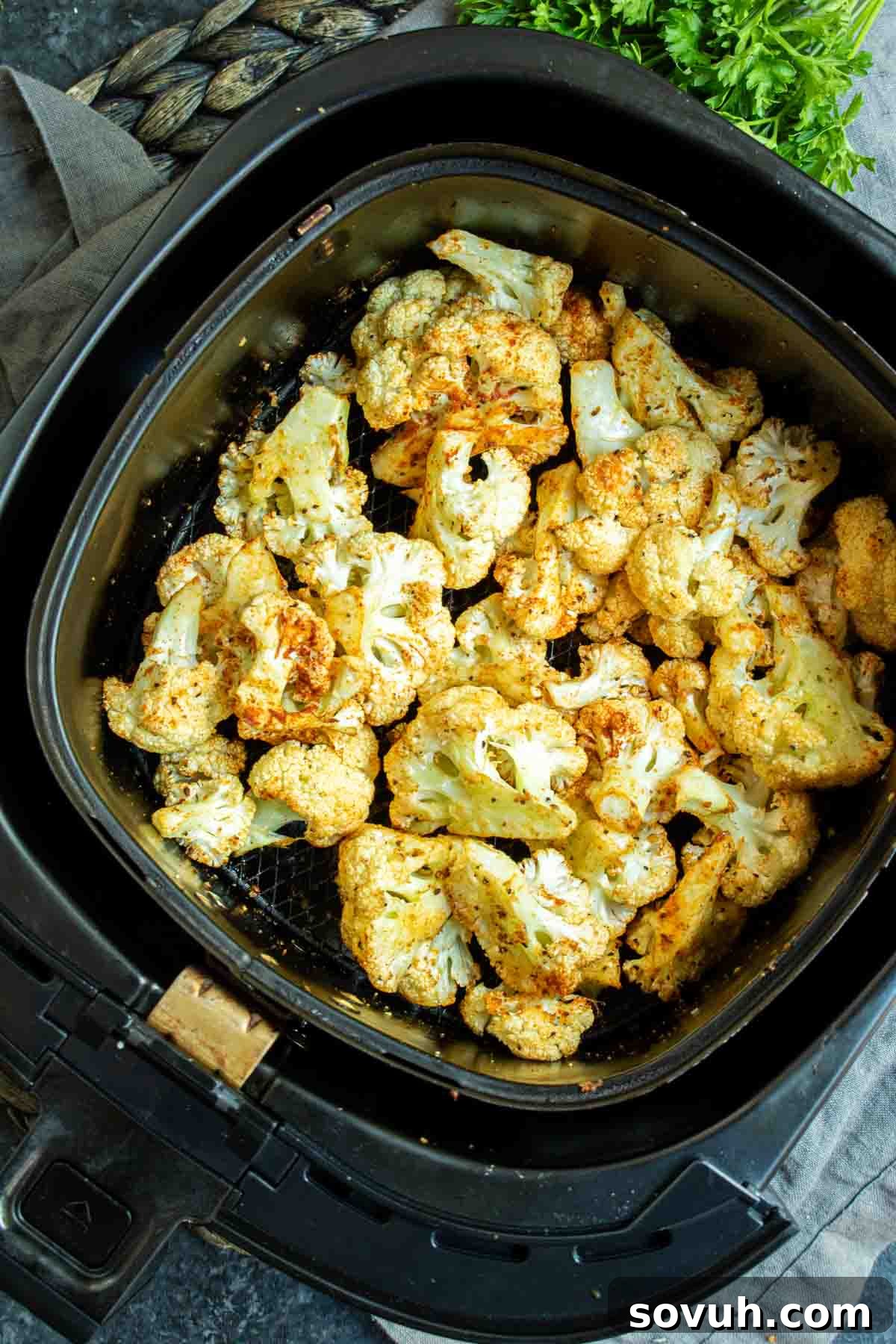 Crispy Air-Fried Cauliflower Bites 4 Crispy roasted cauliflower florets perfectly cooked and arranged in an air fryer basket, ready to be served.
