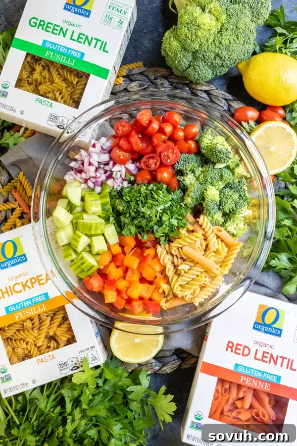 Step-by-step image showing cooked gluten-free pasta and a bowl with pre-cut vegetables ready to be mixed for the vegan pasta salad.
