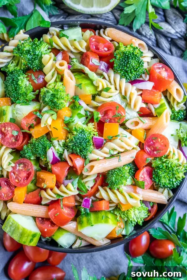 A large bowl filled with vibrant and colorful vegan pasta salad, ready to be served.
