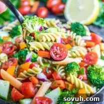 spoonful of vegan pasta salad over a bowl of vegan pasta salad