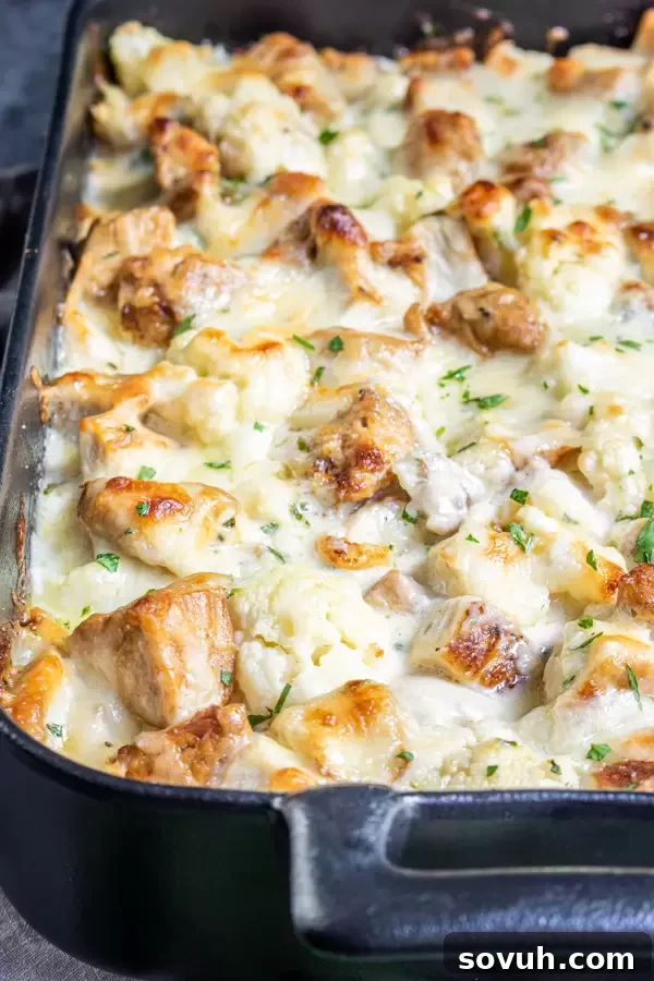 A delicious portion of Keto Chicken Alfredo Casserole in a black serving dish, highlighting its creamy, cheesy texture.