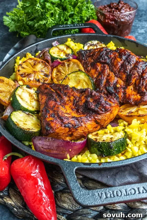 Aromatic Harissa Glazed Chicken 4 Side shot of grilled harissa chicken served in a rustic black dish, highlighting its appetizing charred exterior.