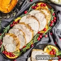 A platter of Instant Pot Turkey Breast, garnished with vibrant orange slices and fresh cranberries, showcasing a perfectly cooked and festive meal.