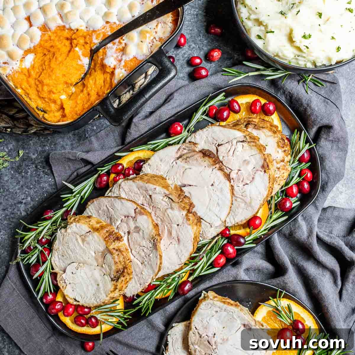 Thanksgiving table with turkey breast, sweet potatoes, and mashed potatoes