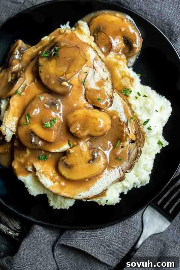 Succulent Turkey Marsala 6 A close-up of a serving of Turkey Marsala on a minimalist black plate, highlighting the tender turkey slices and rich, glossy sauce with mushrooms.