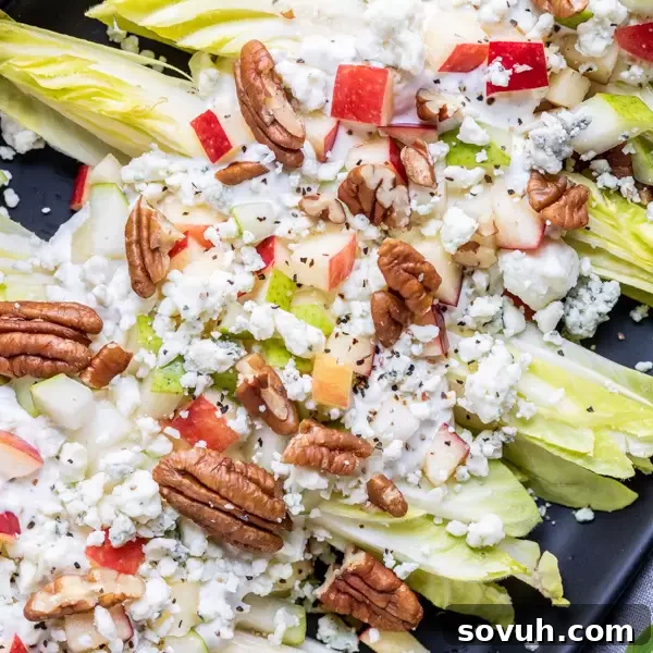 Crisp Endive Salad with candied pecans and crumbled blue cheese, drizzled with dressing.