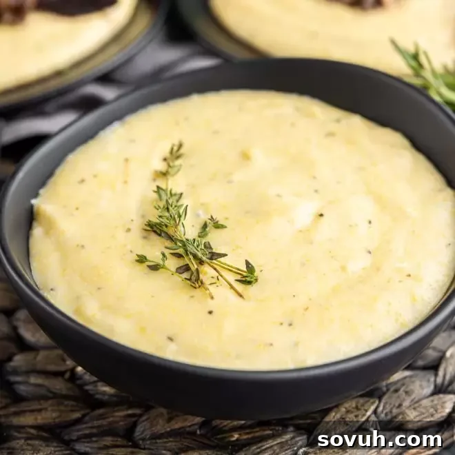Bowl of creamy polenta garnished with fresh thyme, a perfect side dish.