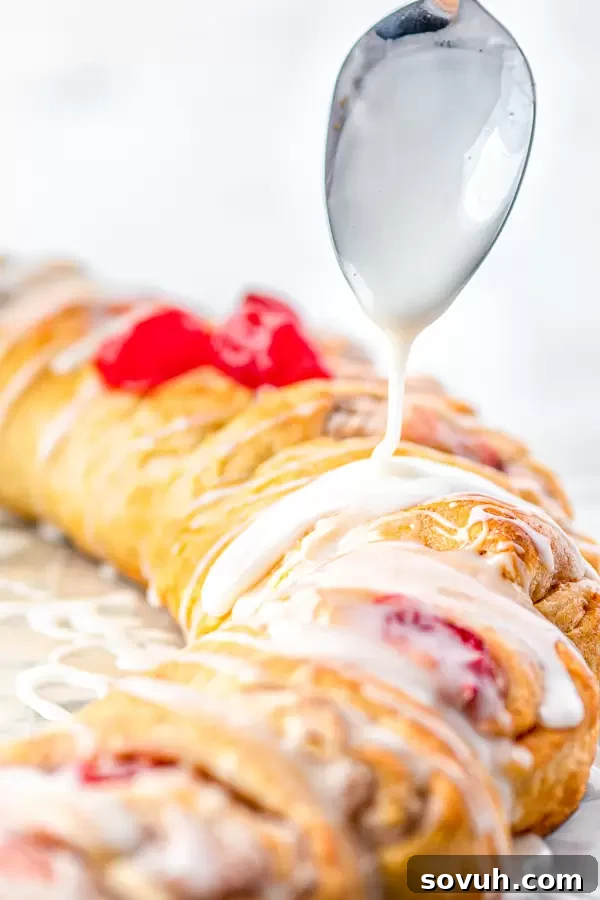 A close-up shot of the Holiday Crescent Ring being drizzled generously with white icing, enhancing its festive appearance.