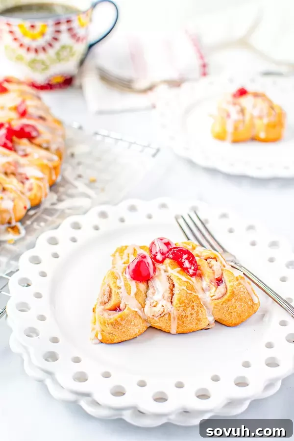 A slice of the Holiday Crescent Roll Breakfast Ring on a white plate with a fork, showing off the perfectly baked dough and rich filling.