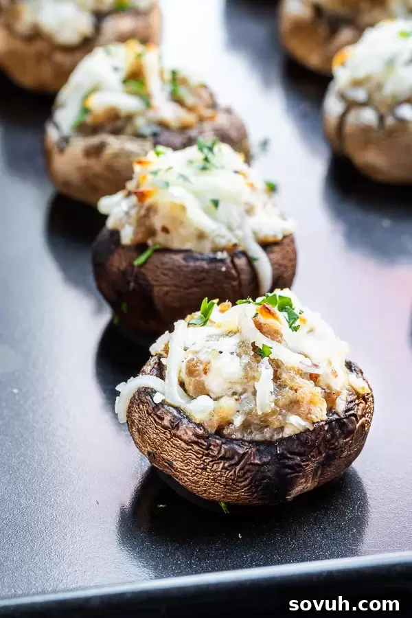 Stuffed Mushrooms with Sausage and Cream Cheese on a black pan, freshly baked.