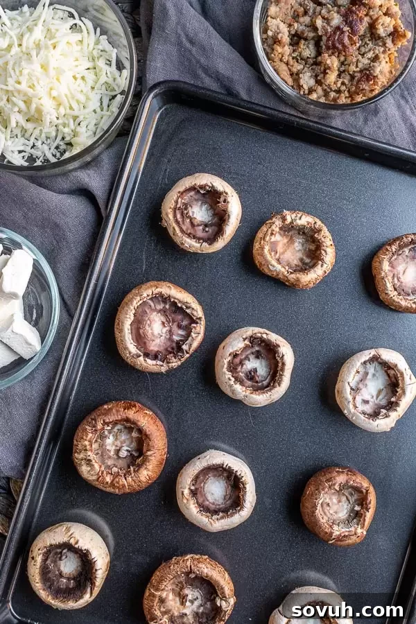 Ingredients for Stuffed Mushrooms with Sausage and Cream Cheese laid out on a kitchen counter.