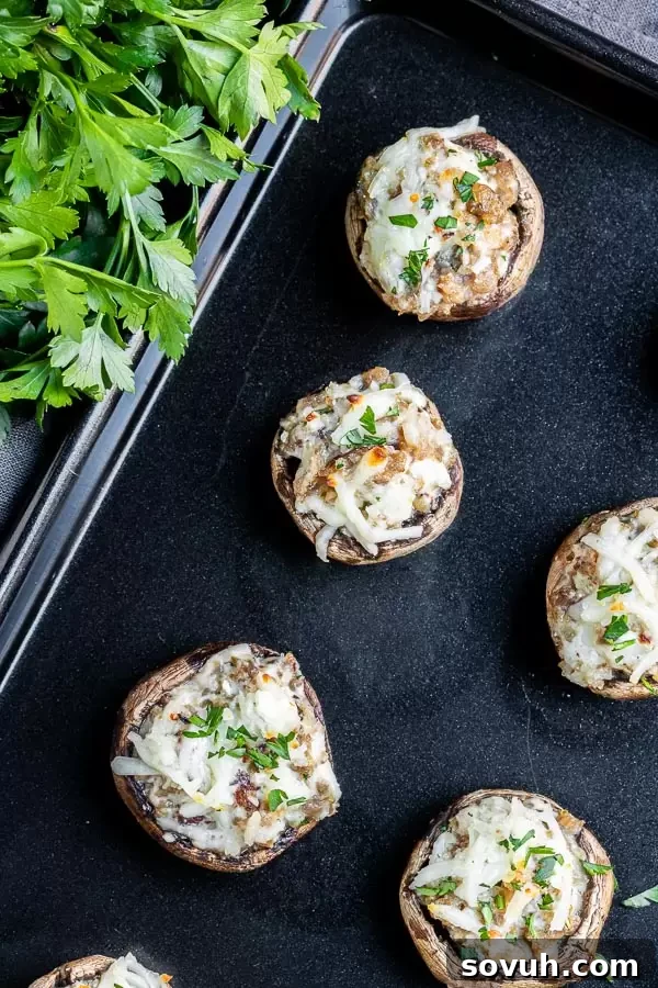Oven baked Stuffed Mushrooms with Sausage on a pan, golden and bubbly.