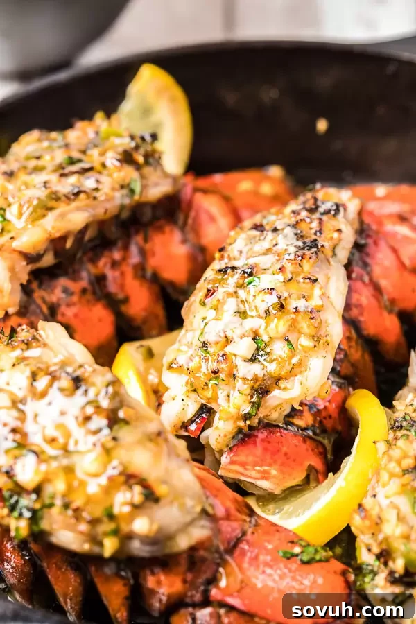 Broiled Lobster Tail in a cast iron skillet, bubbling with melted butter and lemon under the broiler