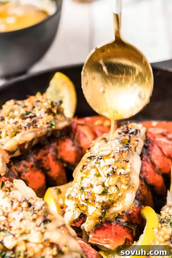 Freshly broiled lobster tails with melted herb butter and lemon wedges, ready to be served
