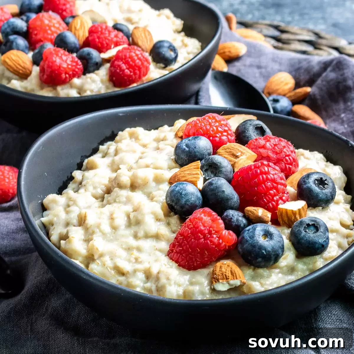 Two black bowls of oatmeal in the Instant Pot, garnished with fresh fruit and nuts, symbolizing a healthy and convenient breakfast.