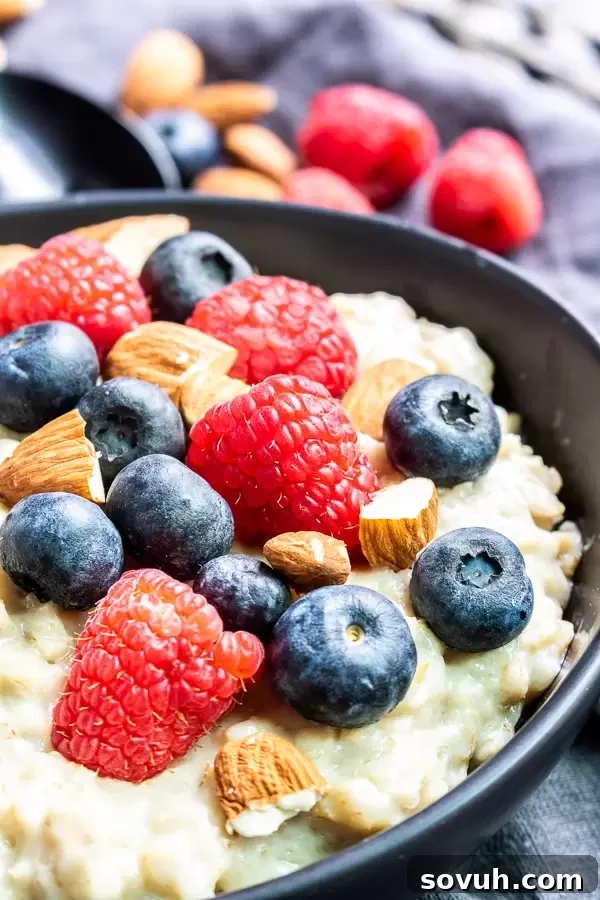 A close-up of a bowl of Instant Pot Oatmeal, generously topped with fresh raspberries, blueberries, and crunchy almonds, emphasizing its delicious appeal.