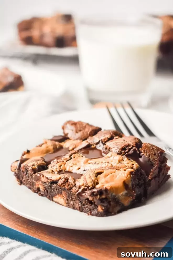 A Dark Chocolate Peanut Butter Brownie on a white plate, served with a refreshing glass of milk.