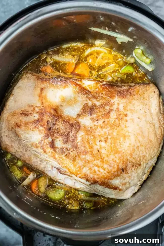 Beef brisket being seared in the Instant Pot before pressure cooking