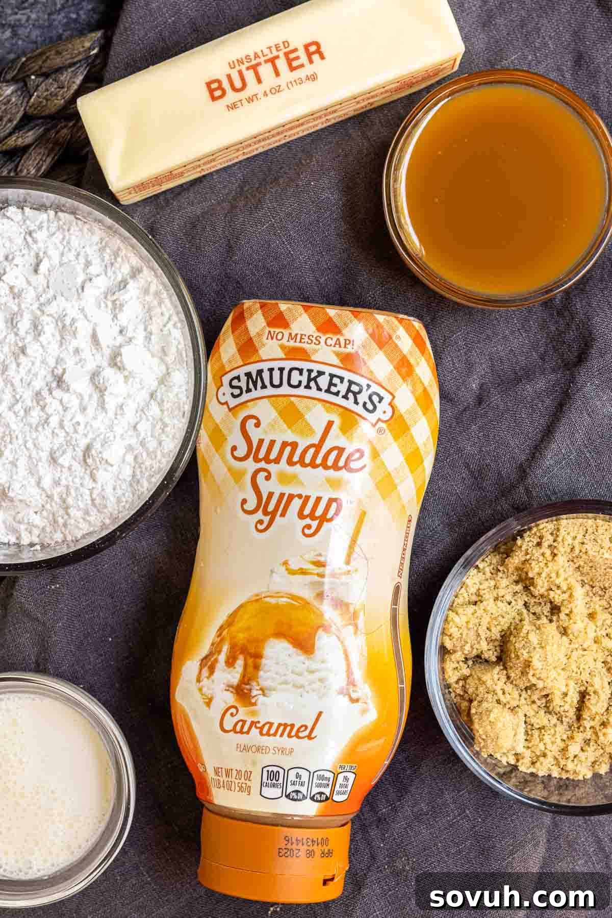 Ingredients for homemade caramel buttercream, including powdered sugar, brown sugar, unsalted butter, and caramel sauce