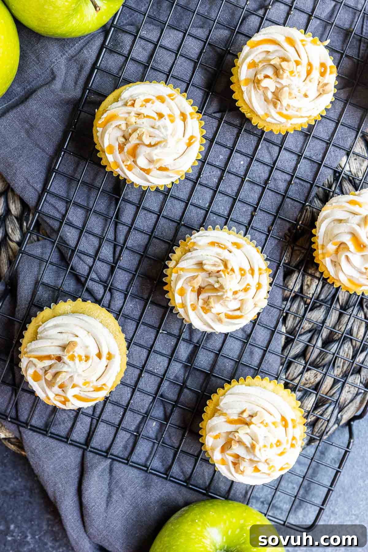 Top-down shot of frosted caramel apple cupcakes with a caramel drizzle