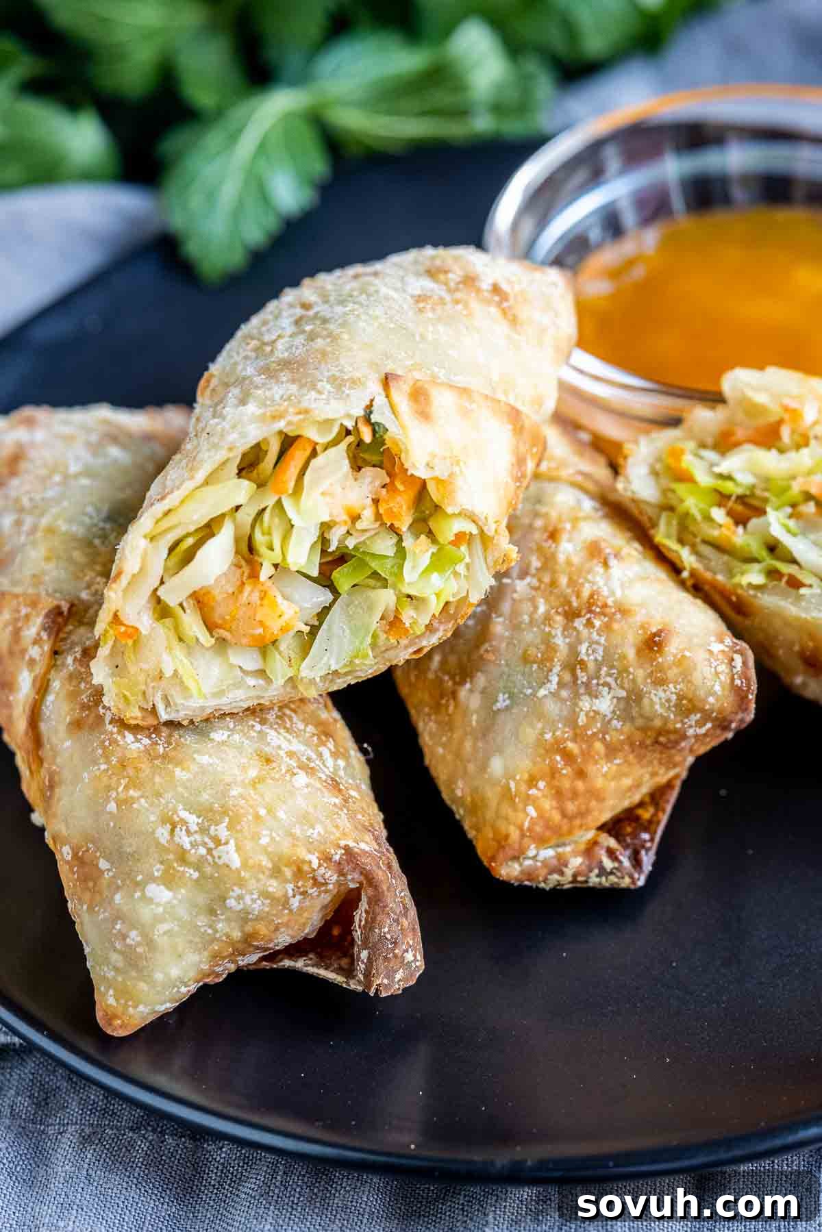 A perfectly cooked Air Fryer Egg Roll cut in half, revealing the savory shrimp and vegetable filling.